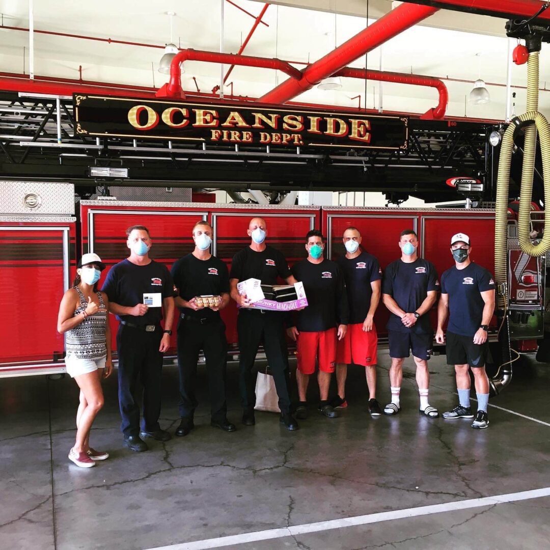 Firefighters pose in front of an Oceanside Fire Department truck.