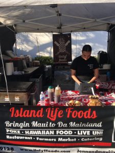 Vendor prepares Hawaiian food at Island Life Foods stall.