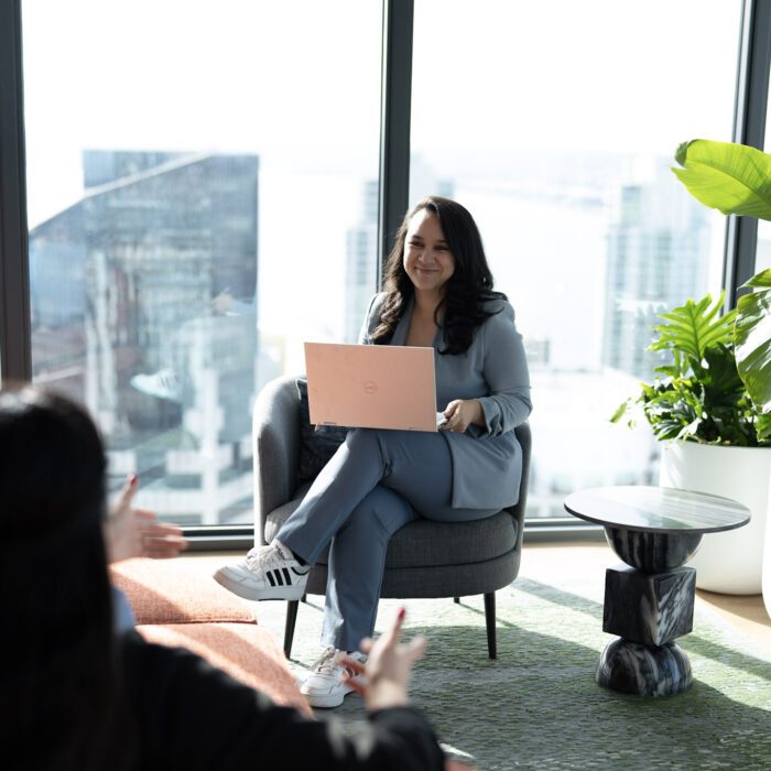 Casual office meeting by window with plant