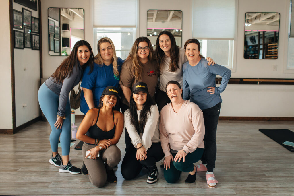 Circle of women posing in a fitness studio