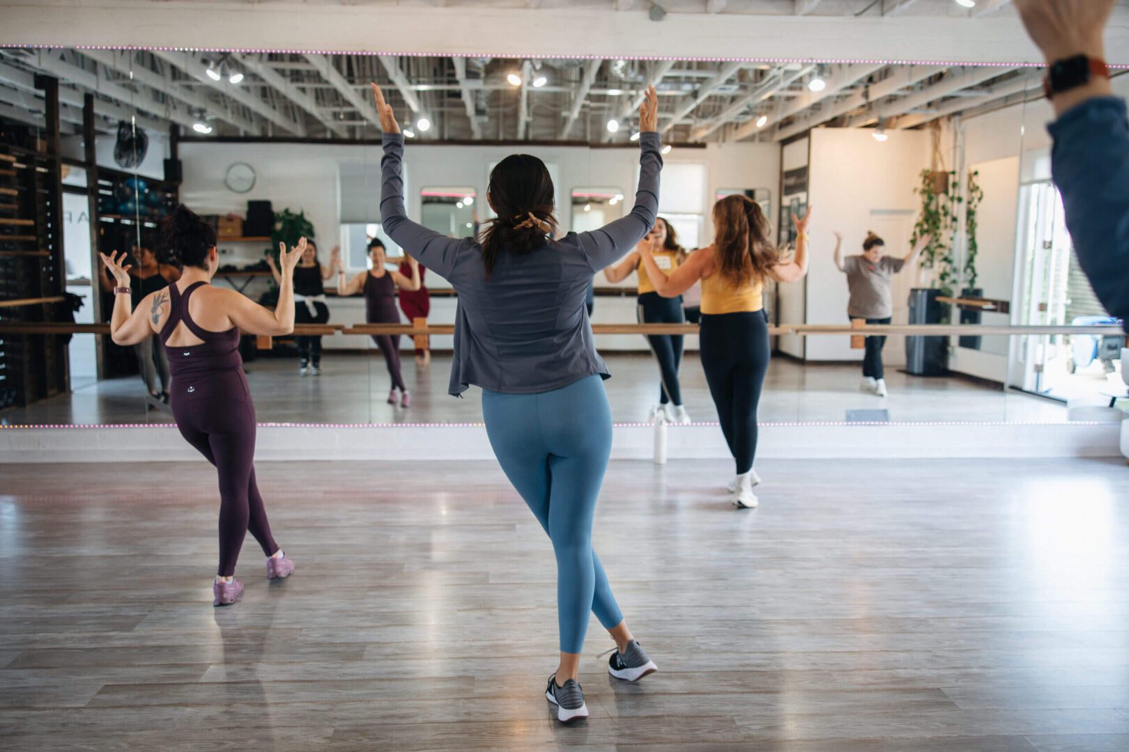 Dance class participants practicing in mirrored studio