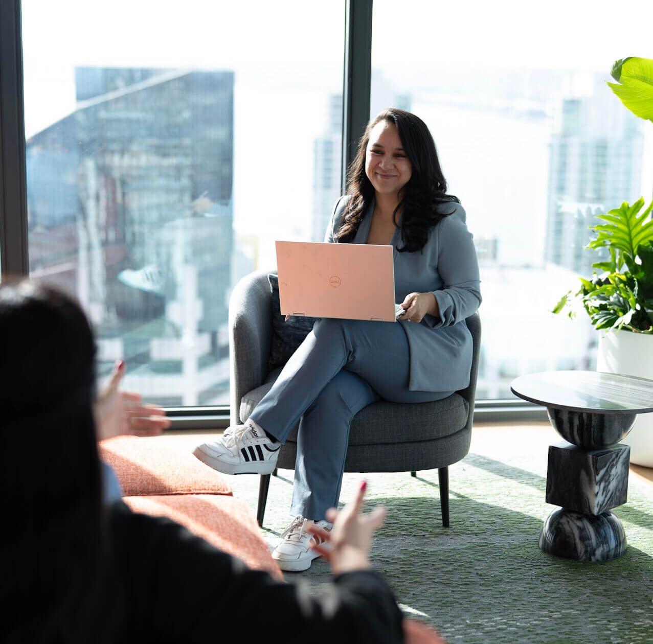 Woman in blue suit smiling with laptop