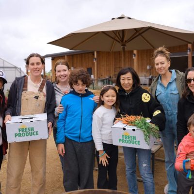 Group posing with farm produce boxes