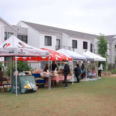 Farmers market booths with shoppers and stalls