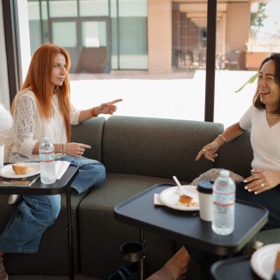 Friends laughing and pointing across couch