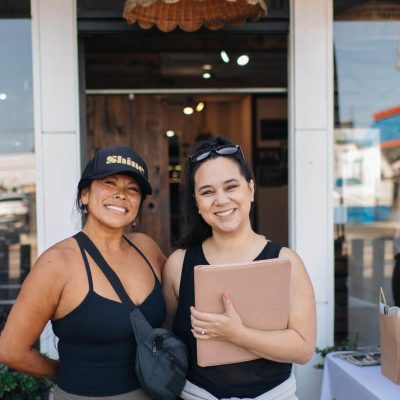 Friends posing in front of studio with gifts
