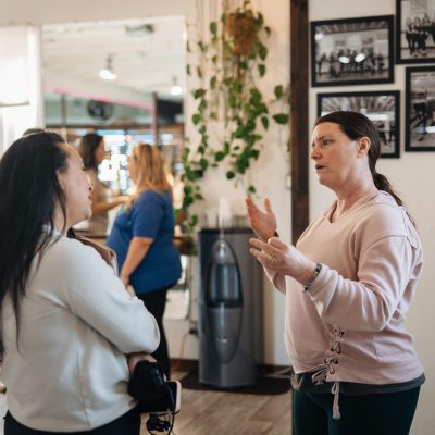 Woman explaining gestures to another in studio