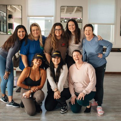 Circle of women posing in a fitness studio