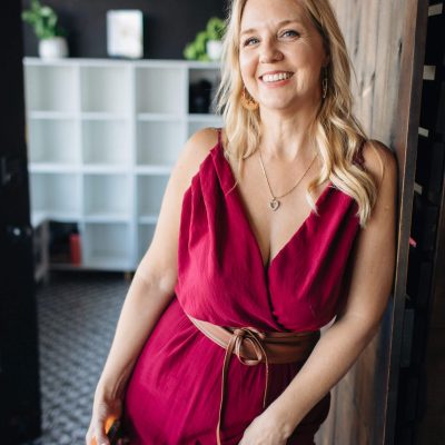 Woman in red dress smiling by doorway